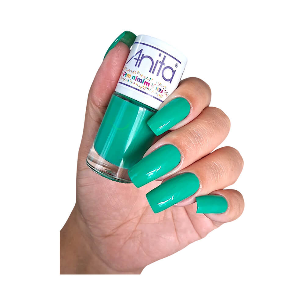 Mão com unhas pintadas com esmalte Anita Carnaval Vem Nimim verde vibrante segurando o frasco do esmalte